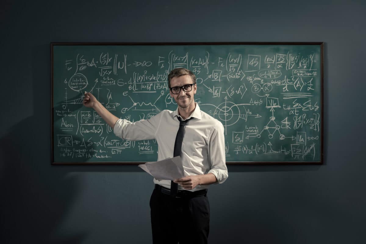 Confident math professor teaching in front of the chalkboard