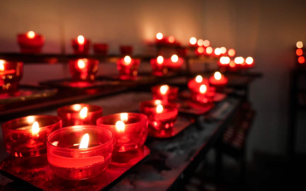 Church Altar Votive Candles. Shallow focus on the foreground prayer candle with background copy space and bokeh.
