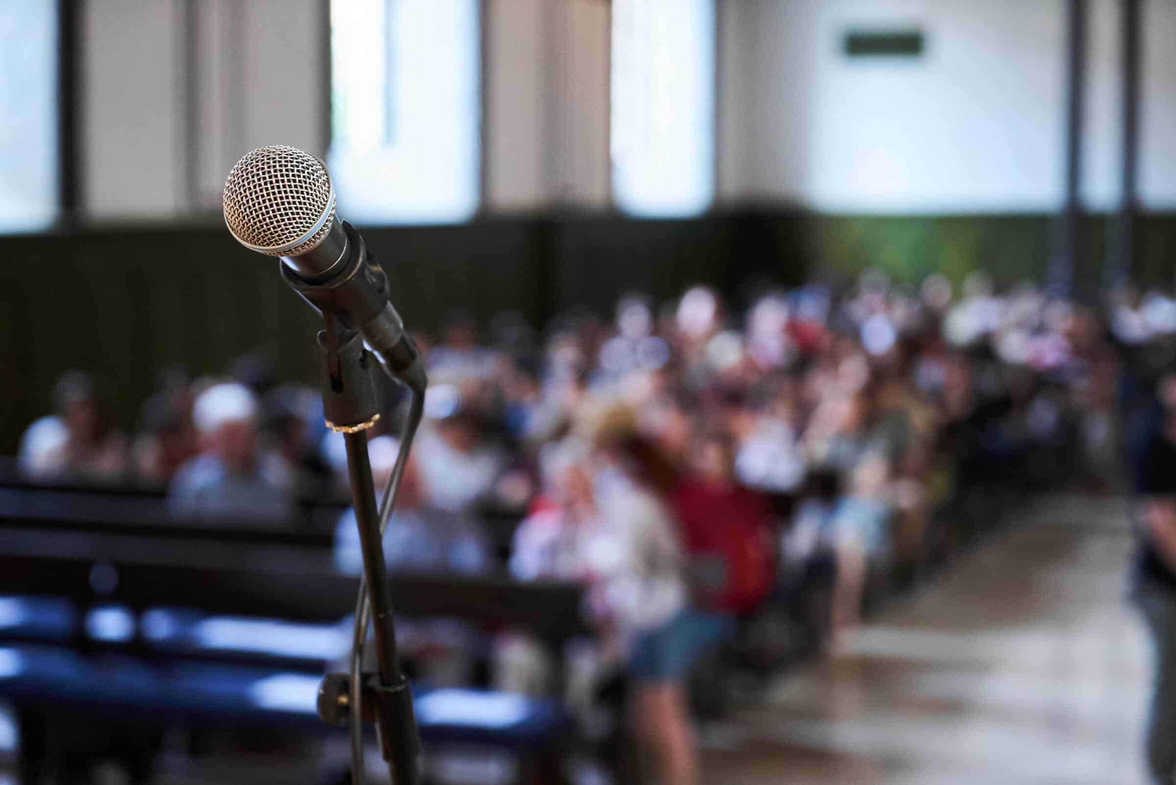 Microphone and abstract blurred conference hall or seminar room background