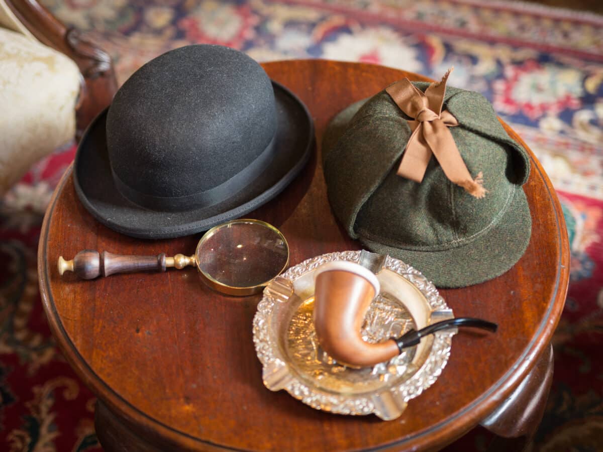 Sherlock Holmes Typical Objects on a Little Wooden Table: Deerstalker, Pipe, Magnifier