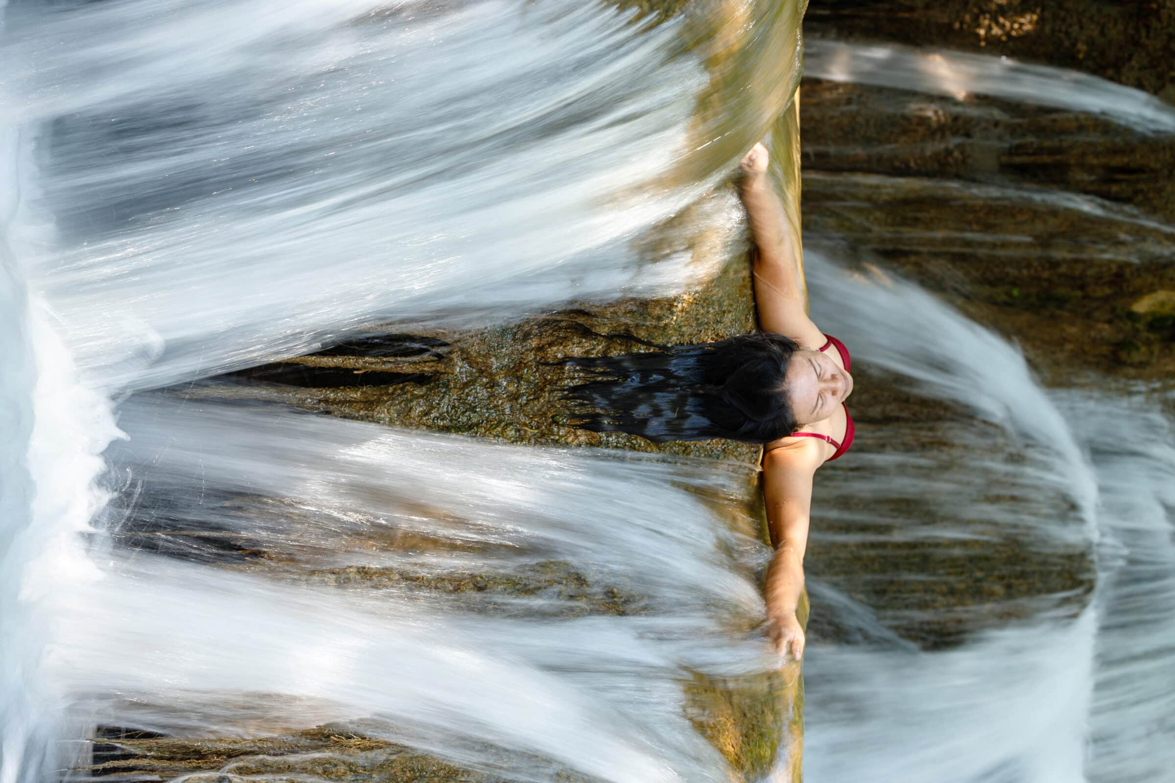 Woman inside waterfall flow