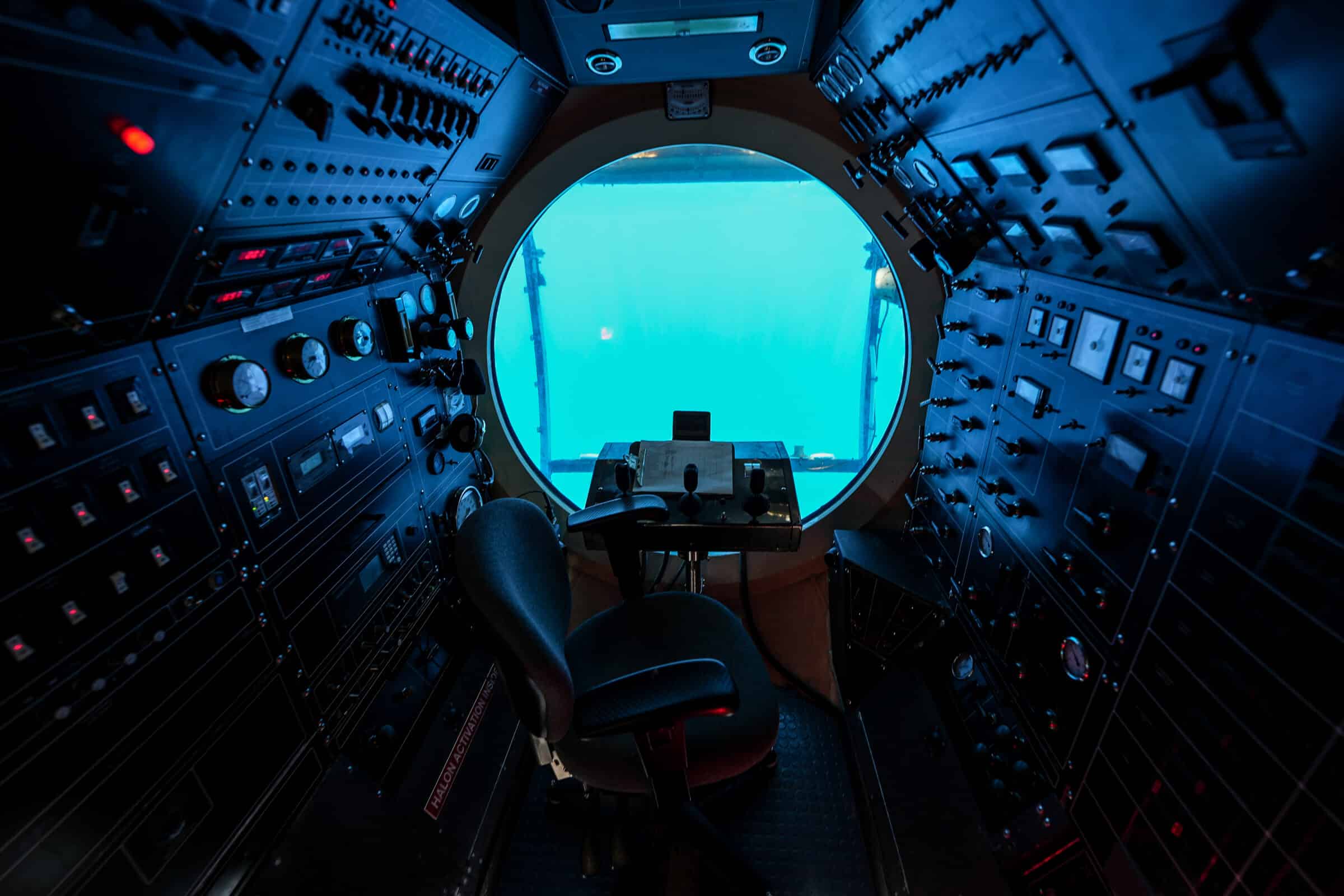 Cockpit of a submarine offering underwater cruises from Waikiki Beach in Honolulu, Hawaii - Round porthole with a steering wheel and dozens of switches used to make a submersible ship dive