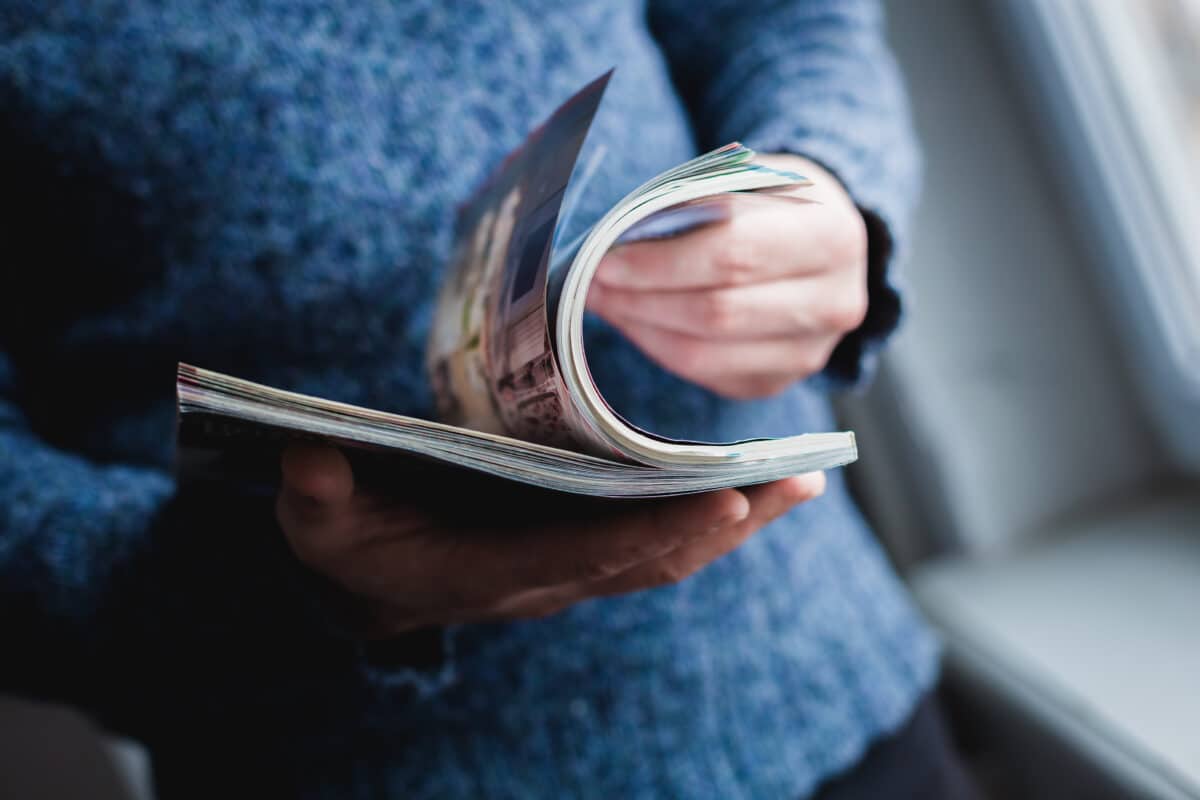 A man looks at a magazine. Press hands.