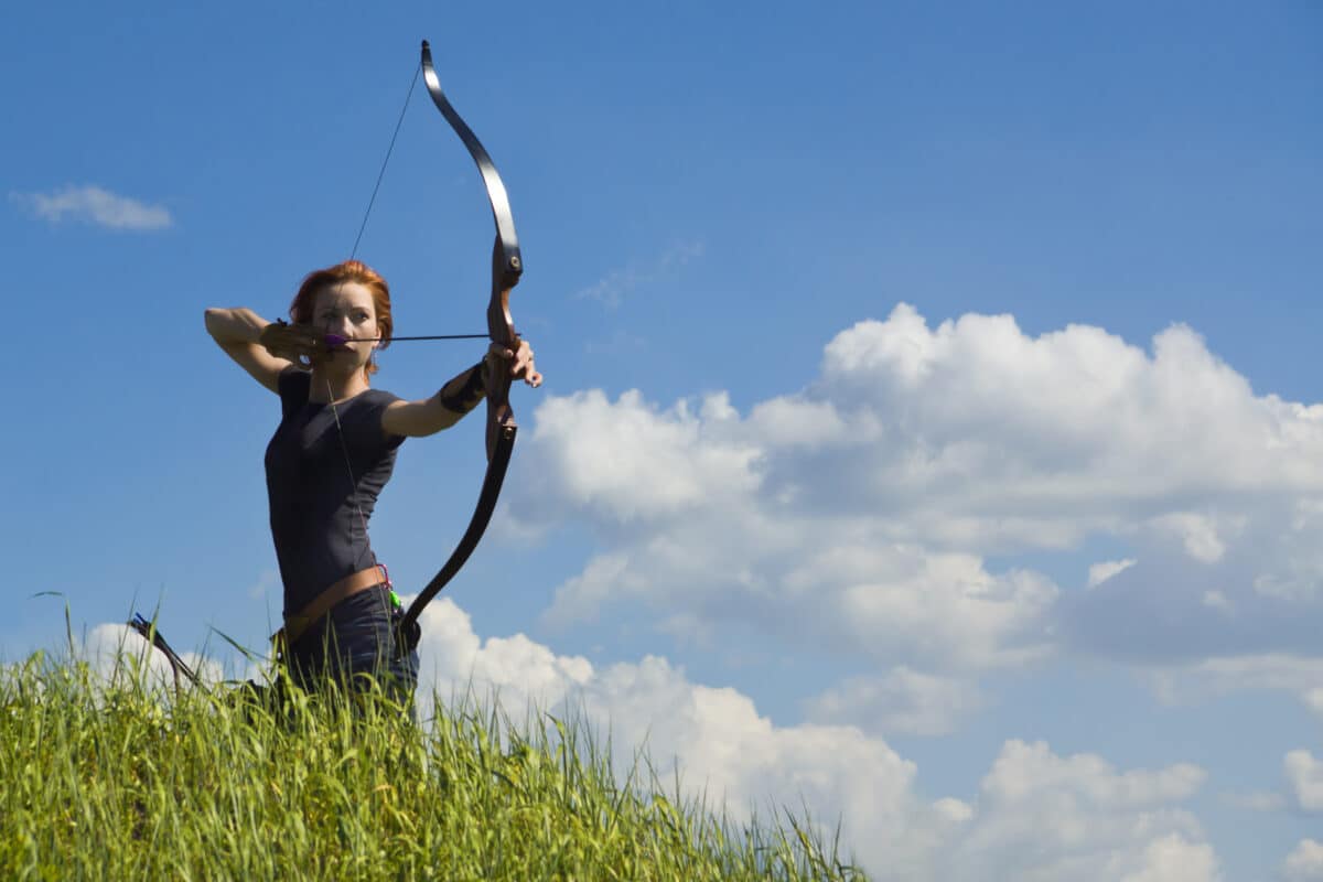 Archery woman bends bow archer target narrow